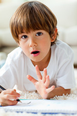 Animated little boy drawing lying on the floor