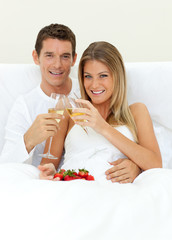 Obraz na płótnie Canvas Romantic couple drinking Champagne with strawberries