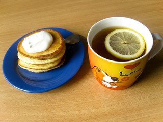 Tea, pancakes with sour cream