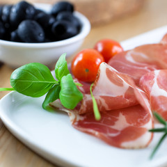Close up of coppa with basil and tomatoes