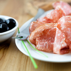 Close up of salami and black olives