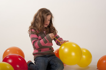 Fototapeta na wymiar little girl tying yellow balloon