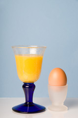 Orange juice and a brown egg
