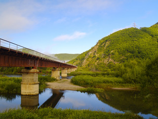 Fototapeta na wymiar The railway bridge at a mountain slope