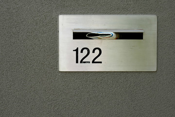 silver metallic letterbox for home in grey wall