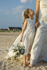Fototapeta na wymiar Bride and Flower Girl on Beach