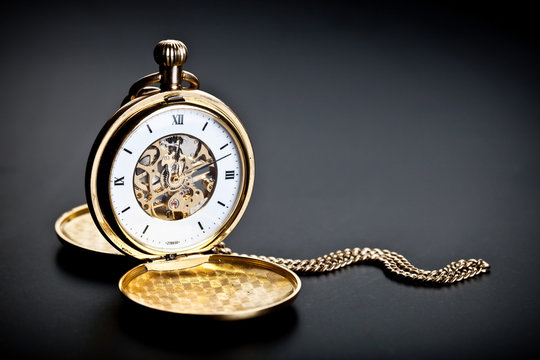 Old vintage pocket clock against the black background