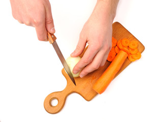 male hand cutting onions and carrot