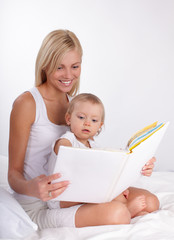 Mother reading book to a daughter