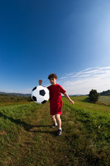 Obraz na płótnie Canvas Boy playing football outdoor