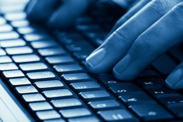 hands typing on laptop