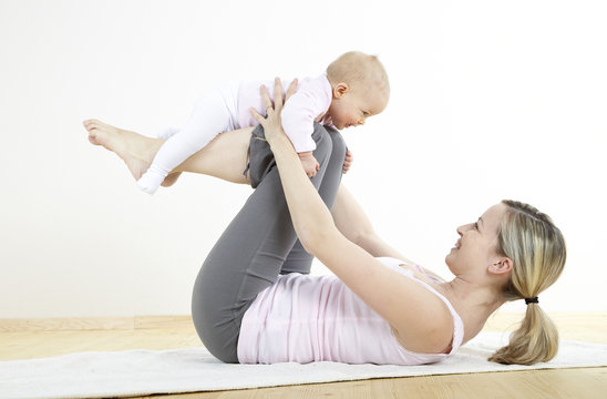 junge mama macht mit ihrem baby fitness + yoga uebungen