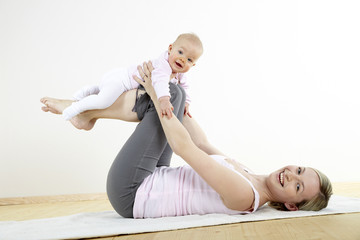 junge mama macht mit ihrem baby fitness + yoga uebungen