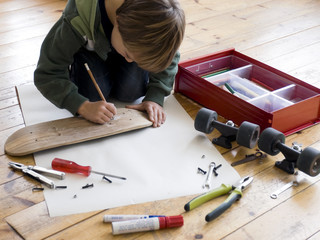 Boy designing his skateboard