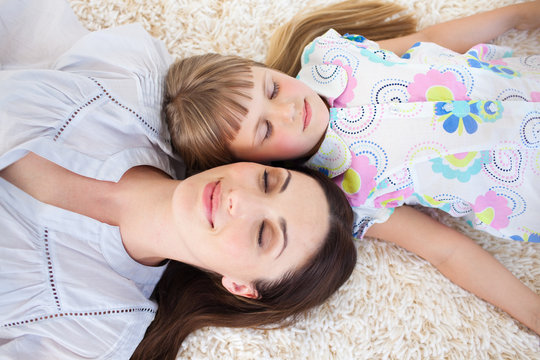 Attractive mother and her daughter lying on the floor