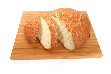 Fresh white bread sliced on a wooden chopping board.
