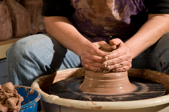 Hands forming clay