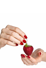Obraz premium Woman hands with red manicure holding delicious strawberry