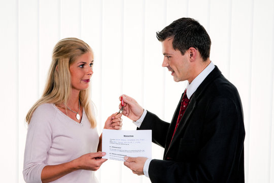 Immobilien Makler und Kundin mit Mietvertrag