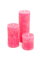 Pink candles over white background