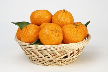 Mandarini con foglie nel cesto