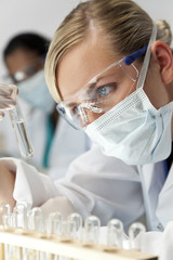 Female Scientific Researcher With Clear Solution In Laboratory