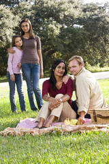 Interracial family enjoying picnic in park