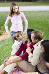 Fototapeta premium Affectionate interracial family of five enjoying picnic together