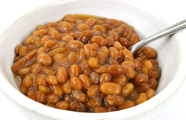 Close view of baked beans in bowl with spoon