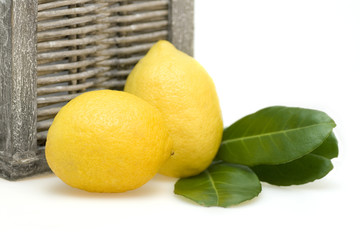Lemons with leafes and wicker basket