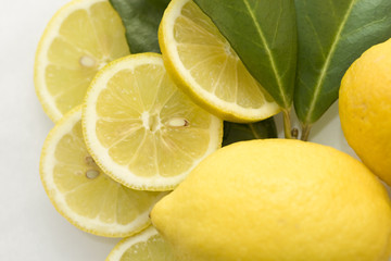 Naklejka na ściany i meble Two lemons and slices of lemon with leafes
