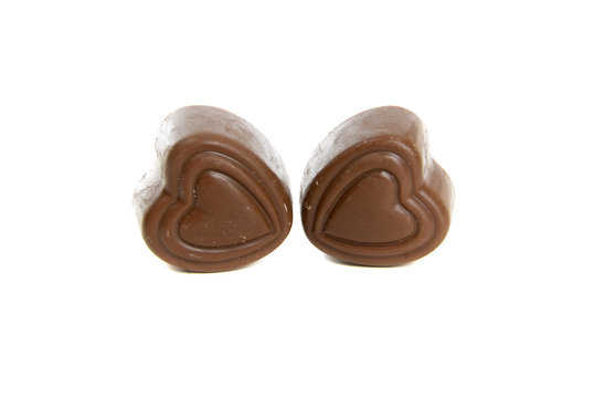 2 heart shaped valentines day chocolates on white