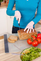 junge frau schneidet brot