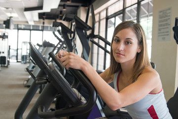 Fototapeta na wymiar Woman Exercising On Stationary Cycle