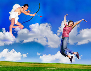 Flying Cupid aiming his bow at young happy woman