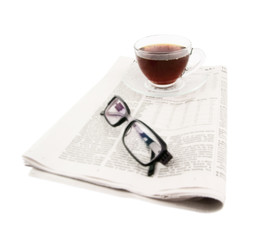Cup of tea with glasses and newspaper isolated