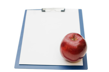 Blank clipboard and an apple isolated on white