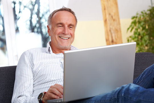 Mature man having fun with laptop