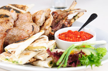Assorted meat grilled with pita, herbs and spicy sauce