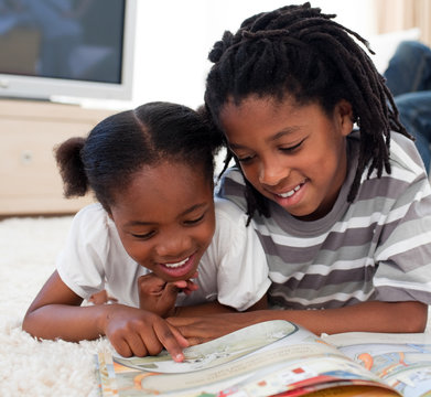 Concentrated Siblings Reading A Book