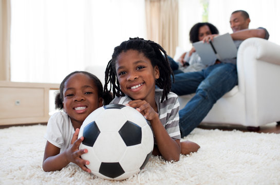 Little boy and his sister holding soccer ball