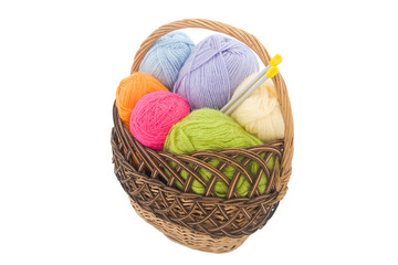 Fototapeta na wymiar colored wool clews with needles in wicker basket