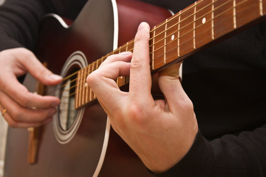 Playing acoustic guitar, barre chord