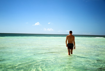 young man walking in Caribbean sea