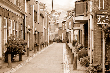 View of small cozy side street in Haarlem in overcast spring day - obrazy, fototapety, plakaty