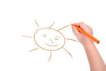 Childrens hand with pencil draws the sun