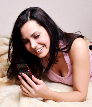 Beautiful young female holding a mobile , reading a message