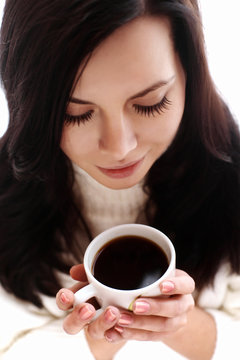 Portrait of a cheerful brunette holding coffee cup