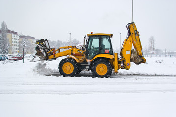 yellow snow plow cleaning a road