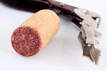 Abridor de vino, con un corcho, sobre un fondo blanco